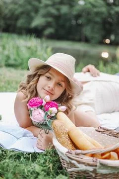 Vertical portrait of charming 9-10-year-old girl with roses in her hand, who Stock Photos