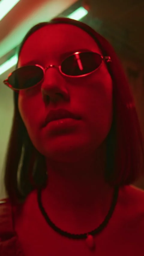 Vertical Portrait of Cool Lady in Oval Sunglasses in Neon Lit Nightclub Stock Footage 280257433