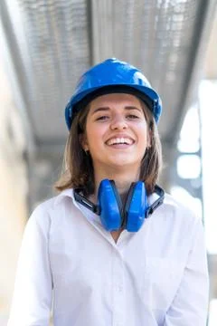 Vertical portrait of engineer with blue hardhat and protective headphones Stock Photos