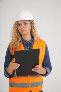 Vertical portrait of female apprentice engineer holding clipboard Foto stock
