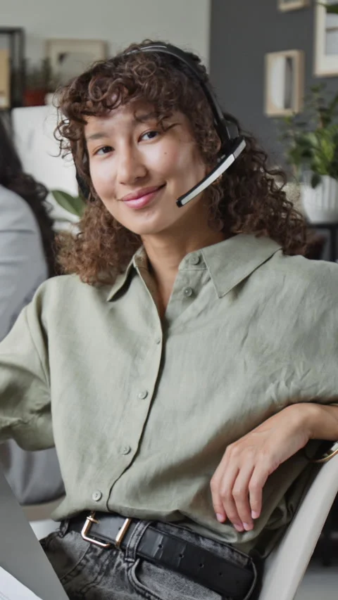 Vertical Portrait of Female Customer Support Agent Wearing Headset and Smiling Stock Footage 343621409