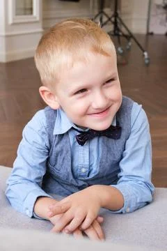 Vertical portrait of a five-year-old blonde boy in a shirt, vest and bow tie Stock Photos