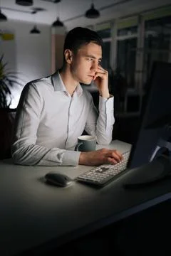 Vertical portrait of IT programmer checking computer code using desktop. Busy Stock Photos