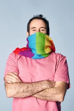 Vertical portrait of madure man covering his face with a rainbow scarf. lgb.. Stock Photos