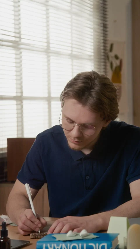 Vertical Portrait of Male Student Writing in Notebook and Smiling Stock Footage 336625432