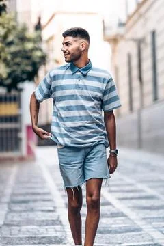 Vertical portrait of a man standing while looking aside distracted in a city Stock Photos
