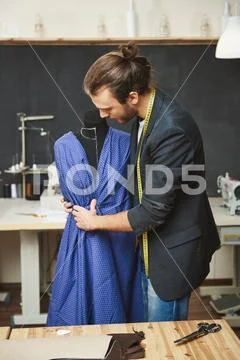 Vertical portrait of manly handsome talented hispanic fashion designer with dark Stock Photos