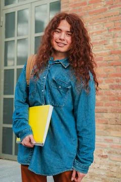 Vertical portrait of a optimistic student standing and looking at camera at Stock Photos