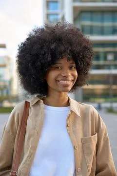 A vertical portrait of a smart student looking aside standing outdoors. Stock Photos
