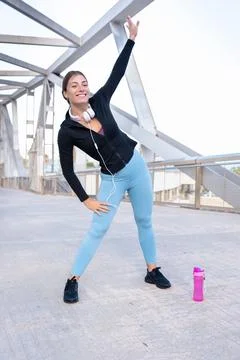 Vertical portrait of smiling runner warming up stretches for cardio exercise. Stock Photos