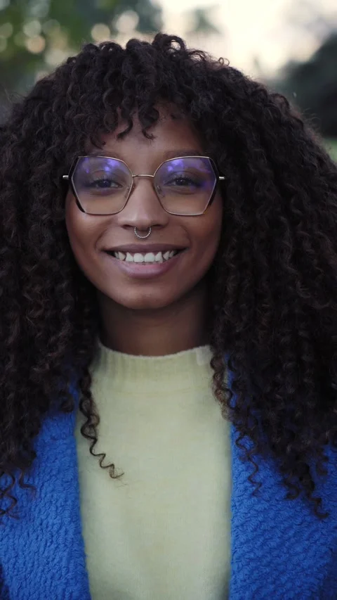 Vertical Portrait of smiling young African woman with curly hair looking camera Stock Footage 229862394