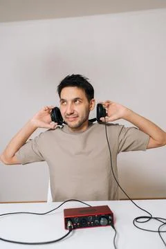 Vertical portrait of sound engineer placing studio headphones on head, working Stock-Fotos