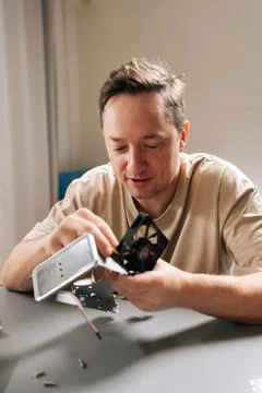 Vertical portrait of technician performing computer repair, using screwdriver to Stock Photos