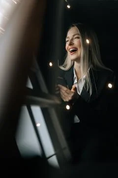 Vertical portrait through windshield to cheerful blonde female reading good news Stock Photos