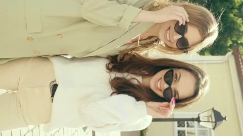 Vertical portrait of two young beautiful smiling hipster girls Stock Footage 142556815