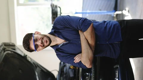 Vertical Portrait Video of Bearded Handsome Car Mechanic is Posing in a Car Stock Footage 203553702
