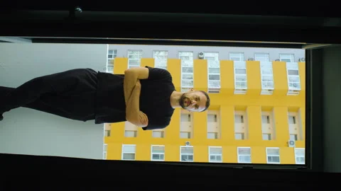 Vertical portrait of young caucasian bearded serious man standing on balcony Stock Footage 167006764