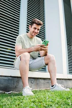 Vertical portrait of a young guy having fun playing a game with a cellphone Stock Photos