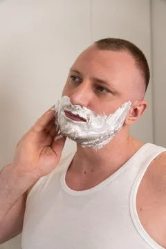 Vertical portrait of young man applying shaving foam before shaving Stock-Fotos