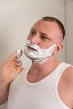 Vertical portrait of young man applying shaving foam before shaving Stock-Fotos