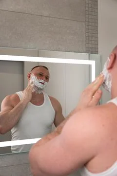 Vertical portrait of young man applying shaving foam before shaving Stock-Fotos