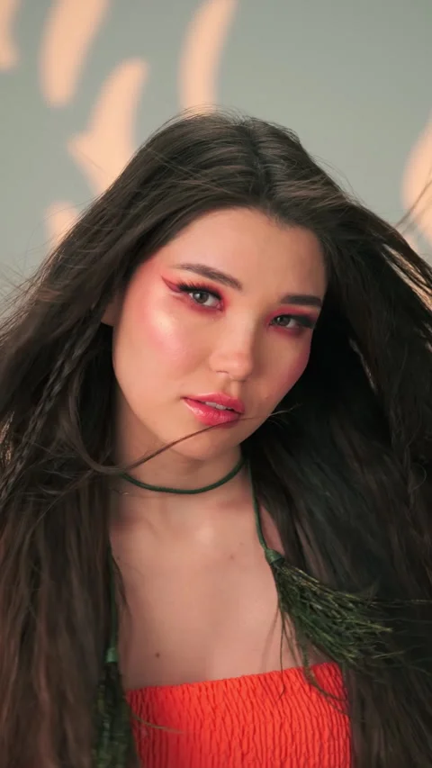 Vertical portrait of a young model with long black hair and bright makeup Stock Footage 340149920
