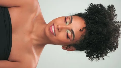 Vertical portrait of young smiling model with curly hair in afro style and Stock Footage 247195428