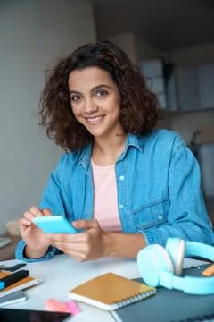 Vertical portrait of young student using smartphone app and looking at camera. Stock Photos
