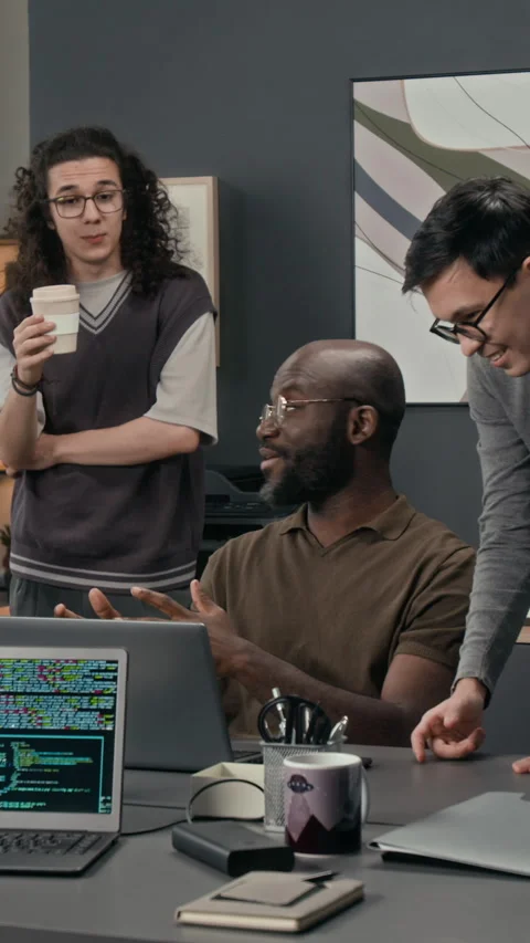 Vertical of Positive IT Specialist Sharing Idea with Two Gen Z Programmers Stock Footage 329617836