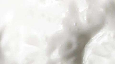 Vertical pouring white milk, close-up splashing fresh drink with drops and foam Vídeos de archivo 251111939