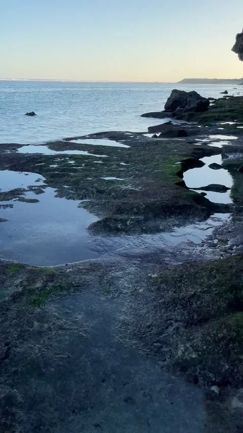 Vertical POV Barefoot Walk on Rocks Revealing Blue Ocean in Bali Stock Footage 337336686