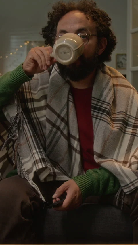 Vertical POV of Middle Aged Man Wrapped in Blanket Drinking Hot Beverage Stock Footage 341675624