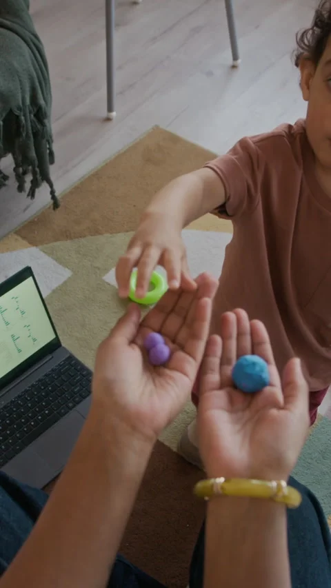 Vertical POV of Mom Modeling Clay with Son and Working on Laptop at Home Stock Footage 334119891