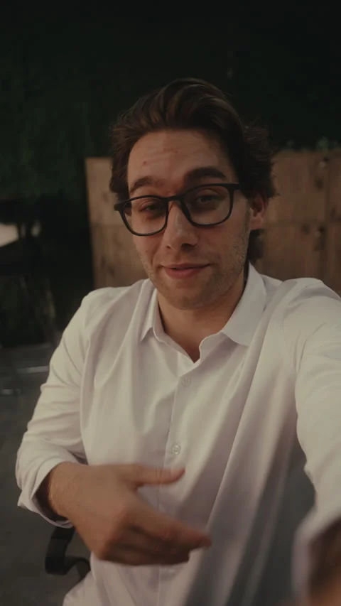 Vertical POV shot young handsome man with glasses records selfie video, talks Stock-Footage 342935434