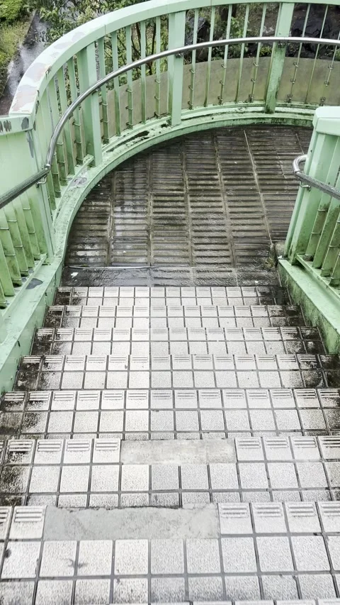 Vertical POV video of walking down spiral pedestrian bridge stairs in Japan Stock Footage 346714163