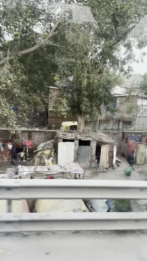 Vertical POV view of roadside makeshift tents slum in New Delhi city India Vídeo Stock 343133130