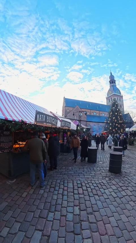 Vertical POV walk through Riga Old Town holiday fair with striped stalls Stock Footage 329018990