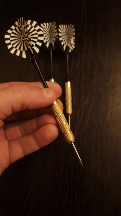 Vertical professional darts for playing darts. A hand is holding Stock Footage 346083040