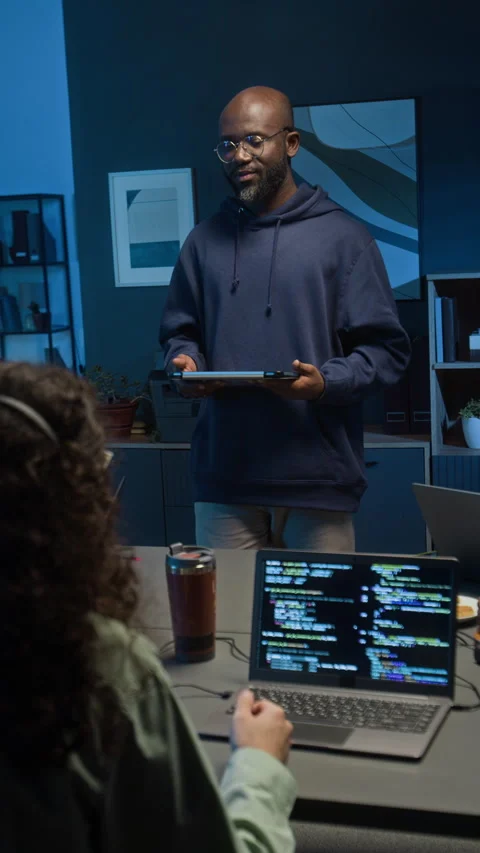 Vertical of Programmer Conversing with QA Specialist in Dimly Lit IT Studio Stock-Footage 329617879