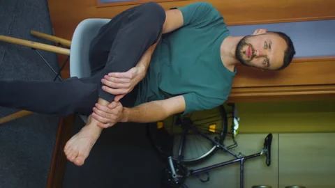 Vertical protrait man looking at camera, sitting at home living room. barefoot Stock Footage 168689979