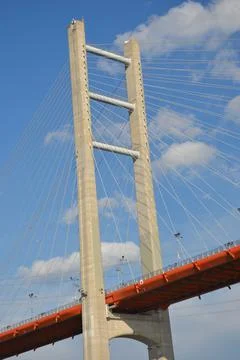 The vertical pylon and diagonal struts of a bridge against a blue sky. Stock Photos
