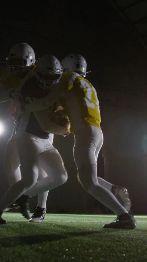 Vertical of Quarterback with Ball Getting Tackled by Rivals during Match Video stock 324591453