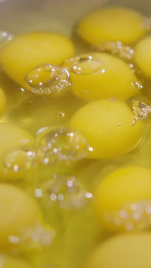 Vertical. Raw eggs fall into metal bowl creating liquid base for dense batter Video stock 324193929