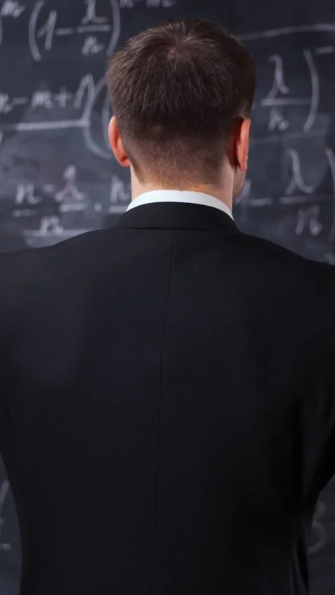 Vertical of Rear view of man against chalkboard with math formula equations Stock Footage 305455482
