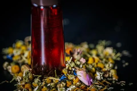 Vertical red bottle with a brown cap stands on a mix of dried. Stock Photos