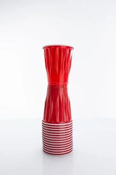 Vertical of a red disposable plastic cup put on a horizontal stack of cups again 库存照片