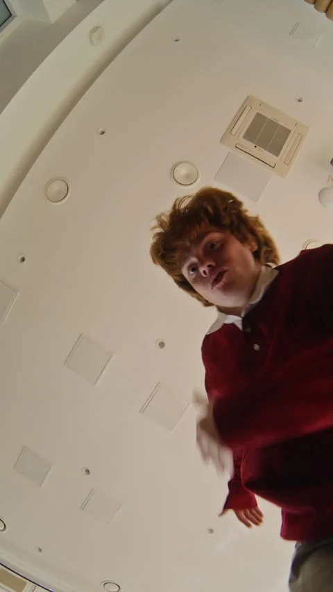 Vertical of Red Haired Man Dancing Directly into Fisheye Camera Stock Footage 343701331