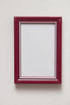 Vertical red plastic frame on indoor white wall Stock Photos