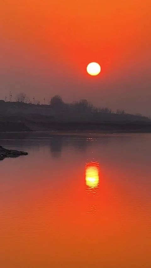 Vertical Red Sunset and Sun Reflection on Calm River Video stock 333488235