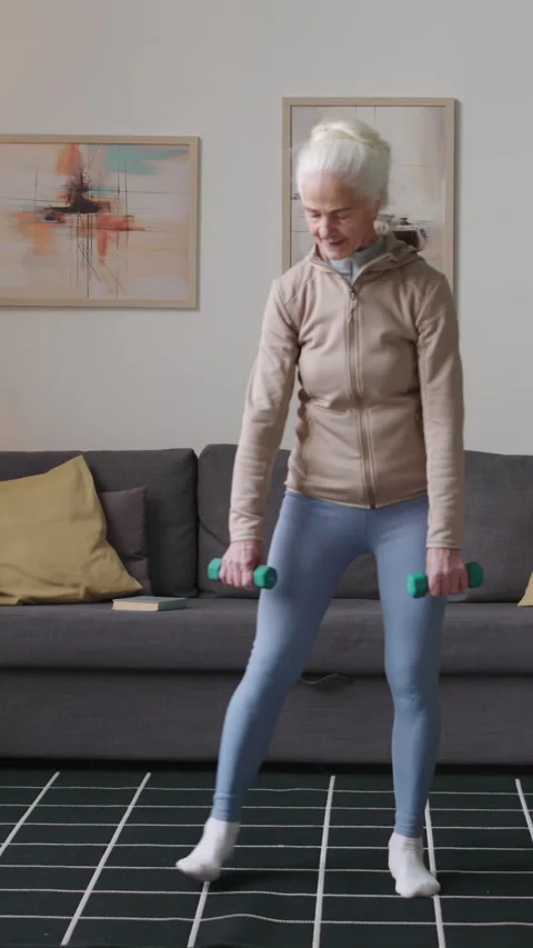 Vertical of Retired Woman Doing Diagonal Lunge Exercise at Home Stock Footage 269490289